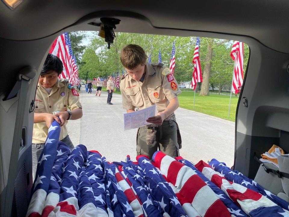 Members of Troop 160 prepare to set up flags on Memorial Day morning at the Ames Municipal Cemetery in 2021.
