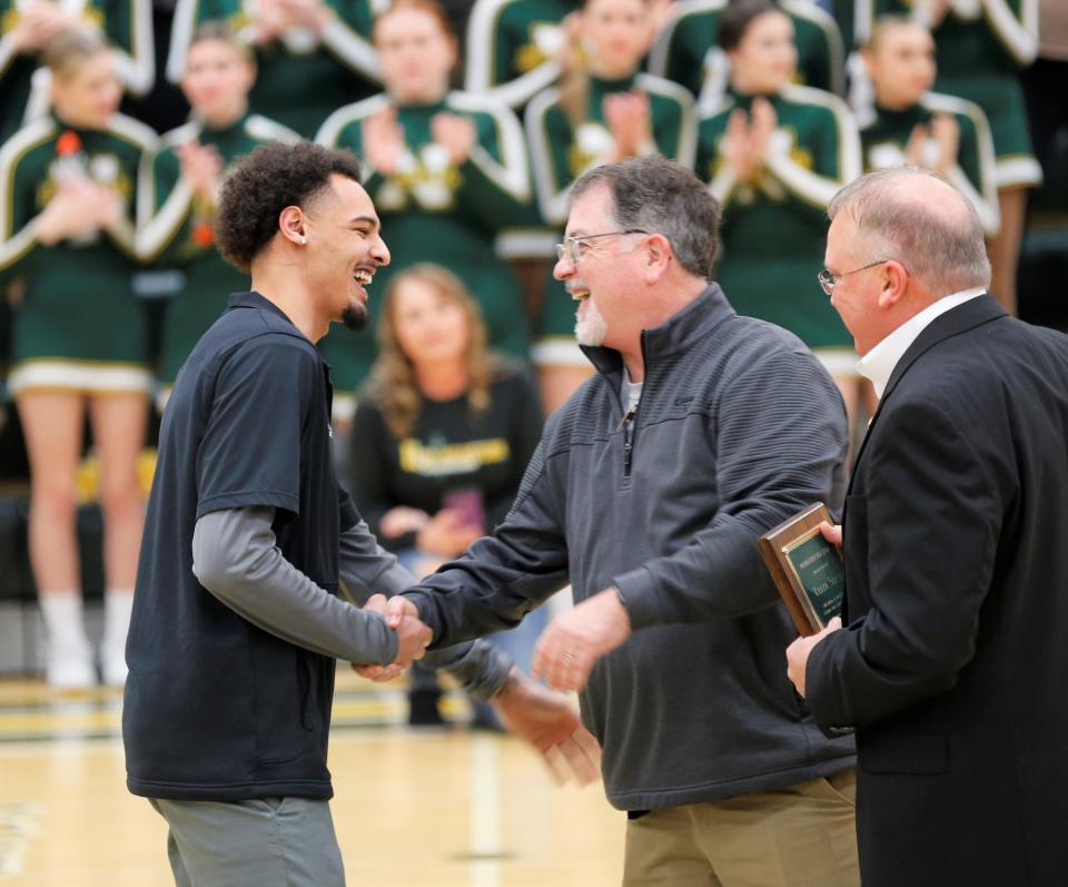 Northeastern graduate Tyler Smith (left) embraces Athletic Director Gerry Keesling (center) and head boys' basketball coach Brent Ross (right) during his jersey retirement ceremony Feb. 17, 2023.