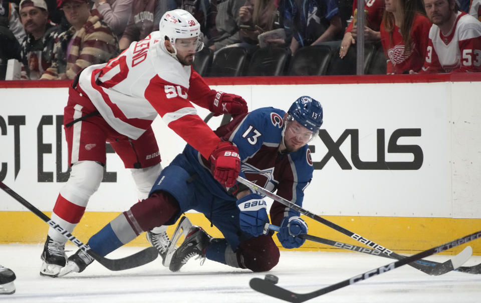 Detroit Red Wings center Joe Veleno, left, battles for control of the puck with Colorado Avalanche right wing Valeri Nichushkin in the first period of an NHL hockey game, Monday, Jan. 16, 2023, in Denver. (AP Photo/David Zalubowski)