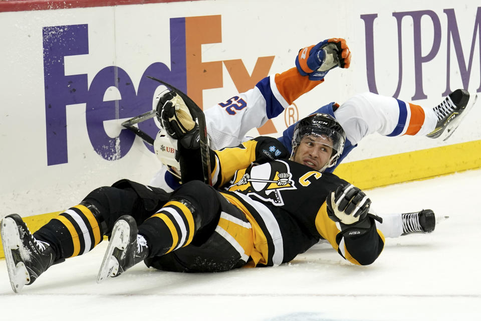 Pittsburgh Penguins center Sidney Crosby (87) collides with New York Islanders defenseman Sebastian Aho (25) during the second period of an NHL hockey game in Pittsburgh, Monday, Feb. 20, 2023. (AP Photo/Matt Freed)