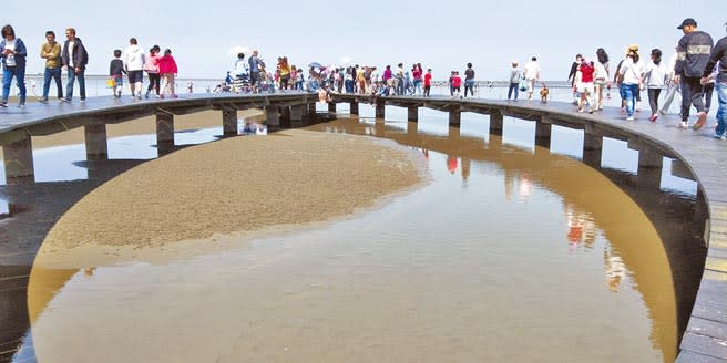 高美溼地遊客漫步在木棧道上近距離觀察水棲生態。（陳淑娥攝）