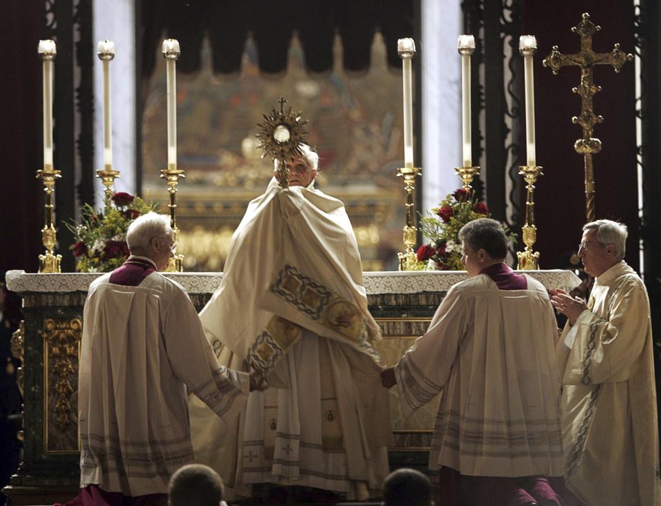 FILE - Pope Benedict XVI hoists a monstrance containing a Holy Host during a Corpus Domini celebration outside St. Mary Major Basilica to mark the feast of the Body and Blood of Christ, in Rome, Thursday, May 26, 2005. (AP Photo/Domenico Stinellis, File)