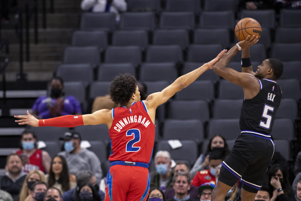 Sacramento Kings guard De'Aaron Fox (5) is fouled by Detroit Pistons guard Cade Cunningham (2) on a shot during the first quarter of an NBA basketball game in Sacramento, Calif., Wednesday, Jan. 19, 2022. (AP Photo/José Luis Villegas)