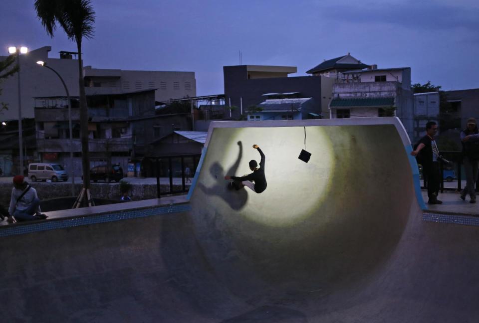 In this Monday, Feb. 13, 2017 photo, a youth plays skates at dusk at Kalijodo Park which is often claimed by the incumbent Jakarta Governor Basuki Tjahaja Purnama who turned the area from a red-light district into a modern skatepark as a legacy of his administration, in Jakarta, Indonesia. Residents of Indonesia's capital vote Wednesday in an election for governor that has become a high-stakes tussle between conservative and moderate forces in the world's most populous Muslim nation. Religion and race, rather than the slew of problems that face a car-clogged and sinking city, have dominated the campaign. (AP Photo/Dita Alangkara)