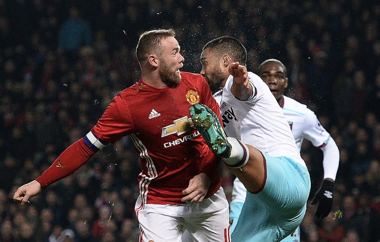 Manchester United's Wayne Rooney (L) reacts after clashing with the foot of West Ham United's Winston Reid at Old Trafford in Manchester, north west England, on November 30, 2016