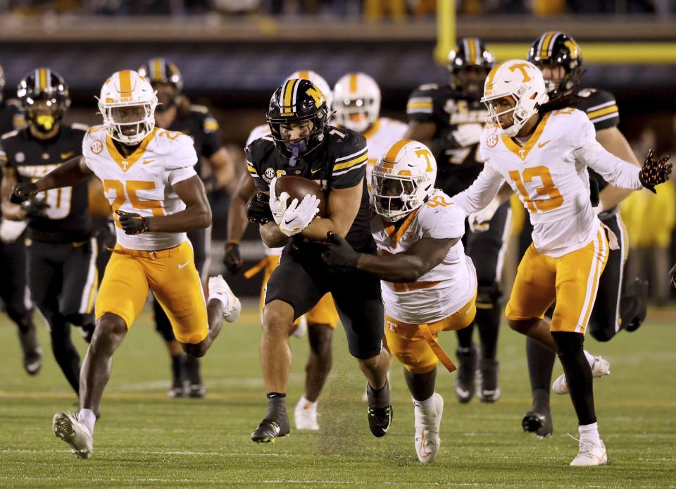 Missouri running back Cody Schrader runs for a long gain as Tennessee defensive lineman Tyre West tries to haul him down during the fourth quarter of an NCAA college football game Saturday, Nov. 11, 2023, n Columbia, Mo. (David Carson/St. Louis Post-Dispatch via AP)