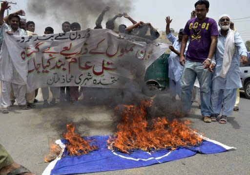 Protesters shout slogans beside a burning NATO flag during a demonstration against drone attacks, in Multan, on June 27. There has been a dramatic increase in US drone strikes in Pakistan since May when a NATO summit in Chicago could not strike a deal to end a six-month blockade on NATO supplies crossing into Afghanistan