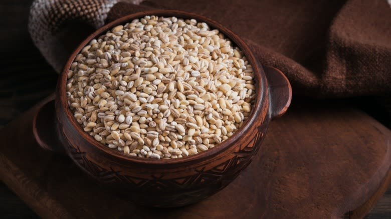 Dried pearl barley in wooden bowl