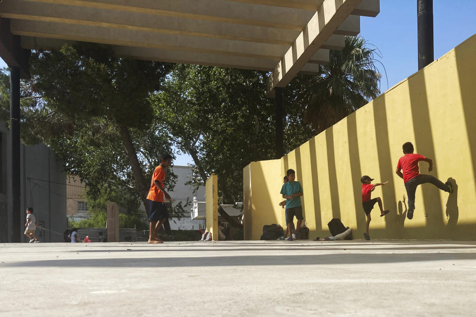 Migrants play at a park where they also sleep in Ciudad Acuña, Mexico, on May 30, 2022 (AP Photo/Elliot Spagat)