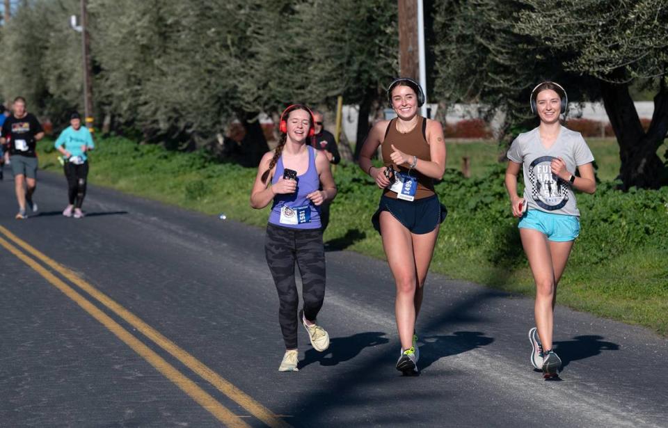 Half marathoners, including Camille Tucker, middle left, and Lia Romeo, middle, at the 9-mile mark on Shoemake Avenue during the Modesto Marathon in Modesto, Calif., Sunday, March 26, 2023.