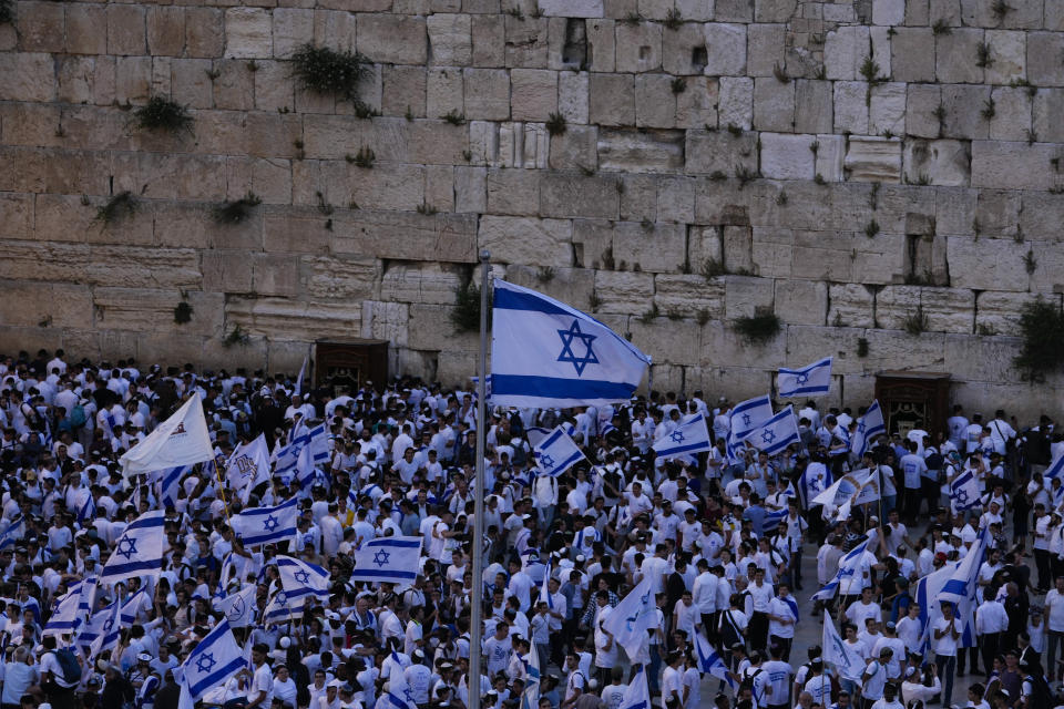 Israelis dance and wave national flags during a march marking Jerusalem Day, an Israeli holiday celebrating the capture of east Jerusalem in the 1967 Mideast war, at the Western Wall, the holiest site where Jews can pray in the Old City of Jerusalem Thursday, May 18, 2023. (AP Photo/Maya Alleruzzo)