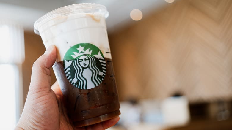 Hand holding coffee with cold foam