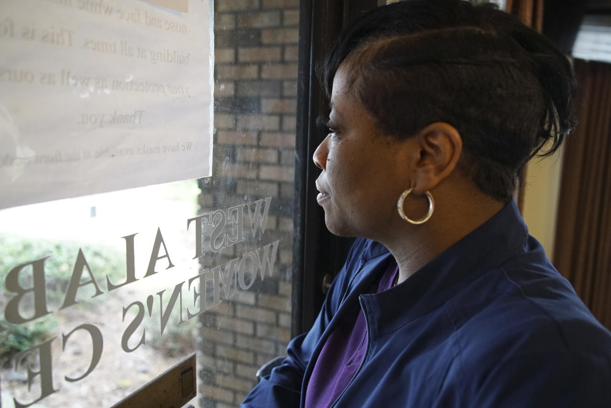 Alesia Horton, director of the West Alabama Women's Center in Tuscaloosa, Ala., looks out the window at protesters on Tuesday, March 15, 2022. A deeply religious woman, she says of those who picket the clinic: 