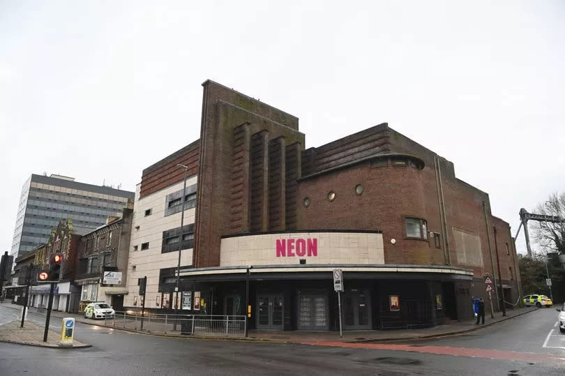 A wide view of The Neon in Newport with police cars visible on either side