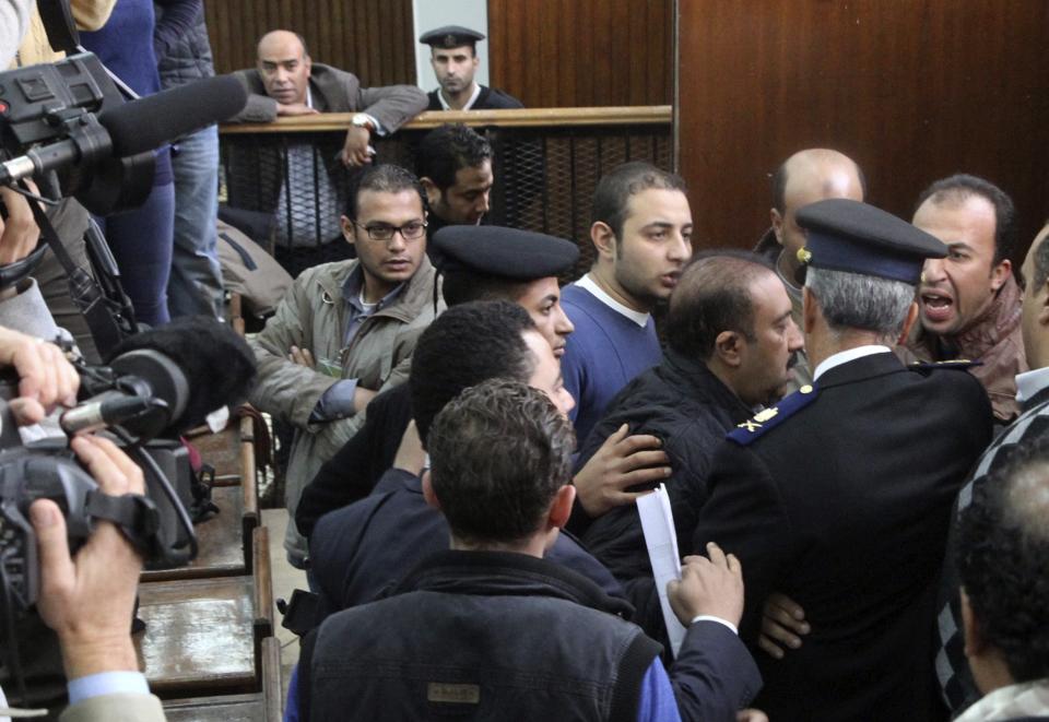 Members of the Muslim Brotherhood argue with policemen during the trial of the Brotherhood leaders in Cairo