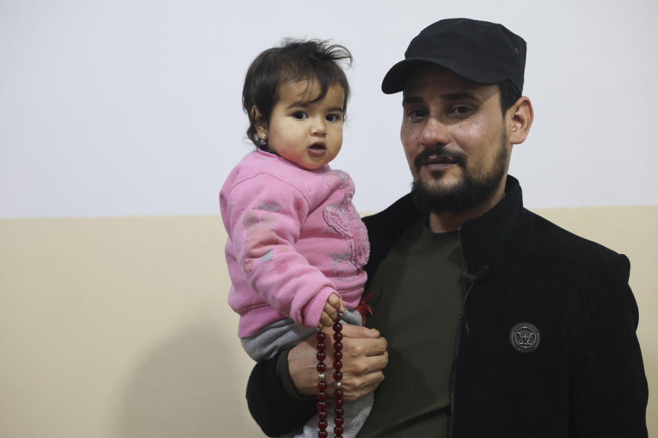 Khalil Al-Sawadi holds a one-year-old Afraa al-Sudani at his home in Jinderis, Syria, Sunday, Feb. 4, 2024. Afraa was pulled alive from the rubble of her family's house in the town of Jinderis in northern Syria, still attached by an umbilical cord to her dead mother on February 6, 2023, after a devastating earthquake hit Turkey and Syria. Afraa is the only surviving member of her immediate family. (AP Photo/Ghaith Alsayed)