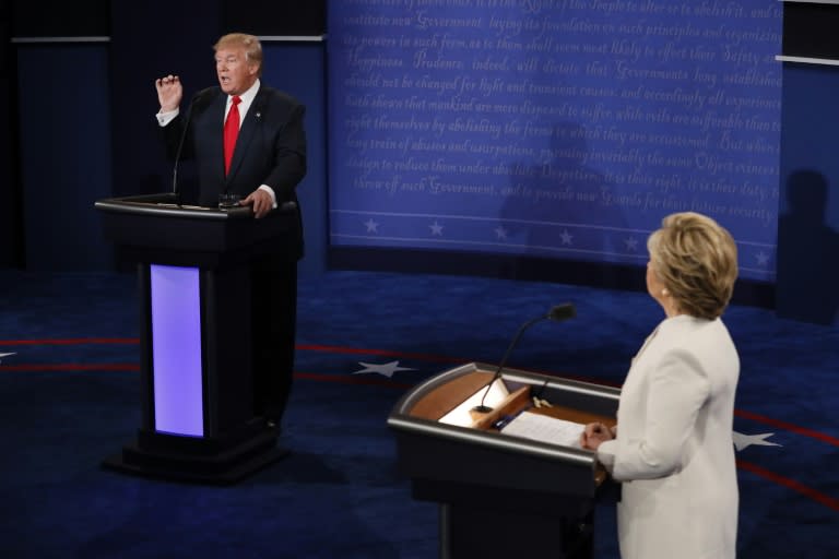 Republican presidential nominee Donald Trump speaks as Democratic presidential nominee Hillary Clinton (R) looks on during the final presidential debate in Las Vegas