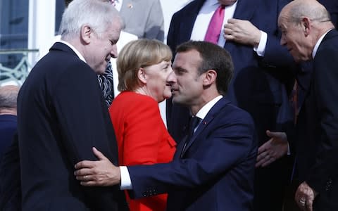Mr Macron greets Germany's Interior Minister, Horst Seehofer, who has issued Mrs Merkel an ultimatum on migration - Credit: Michele Tantussi/Getty Images