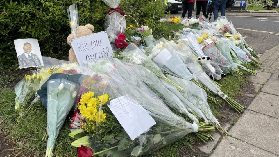 Flowers with one note which says 'RIP little angel'