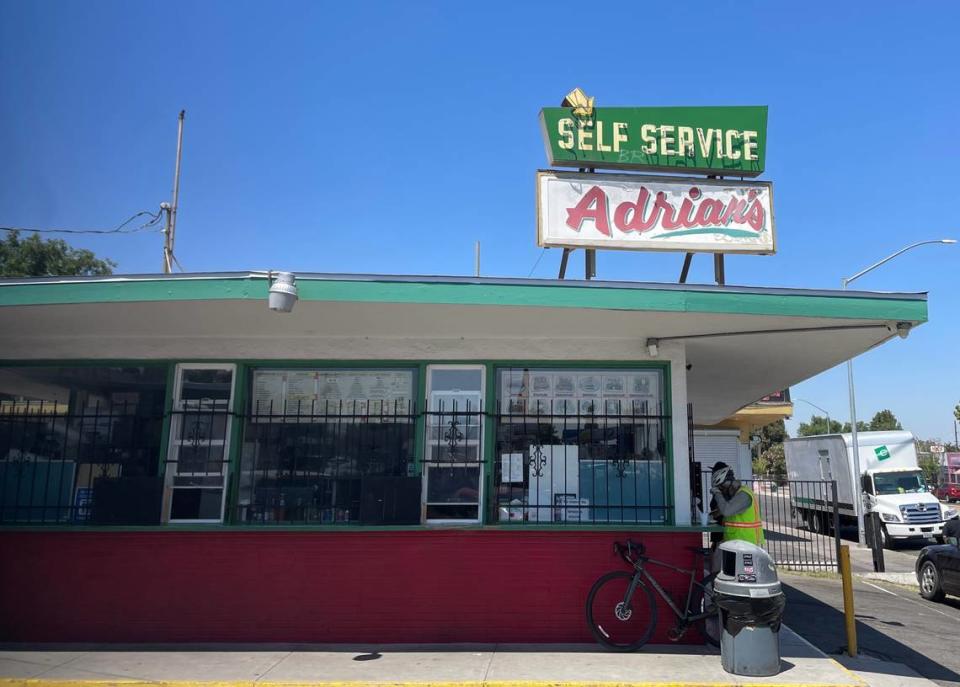 Pete González, a la derecha, come un burrito de chile verde y un taco de res en el mostrador de Adrian's en   Belmont Avenue, en Fresno, el jueves 21 de junio de 2024.