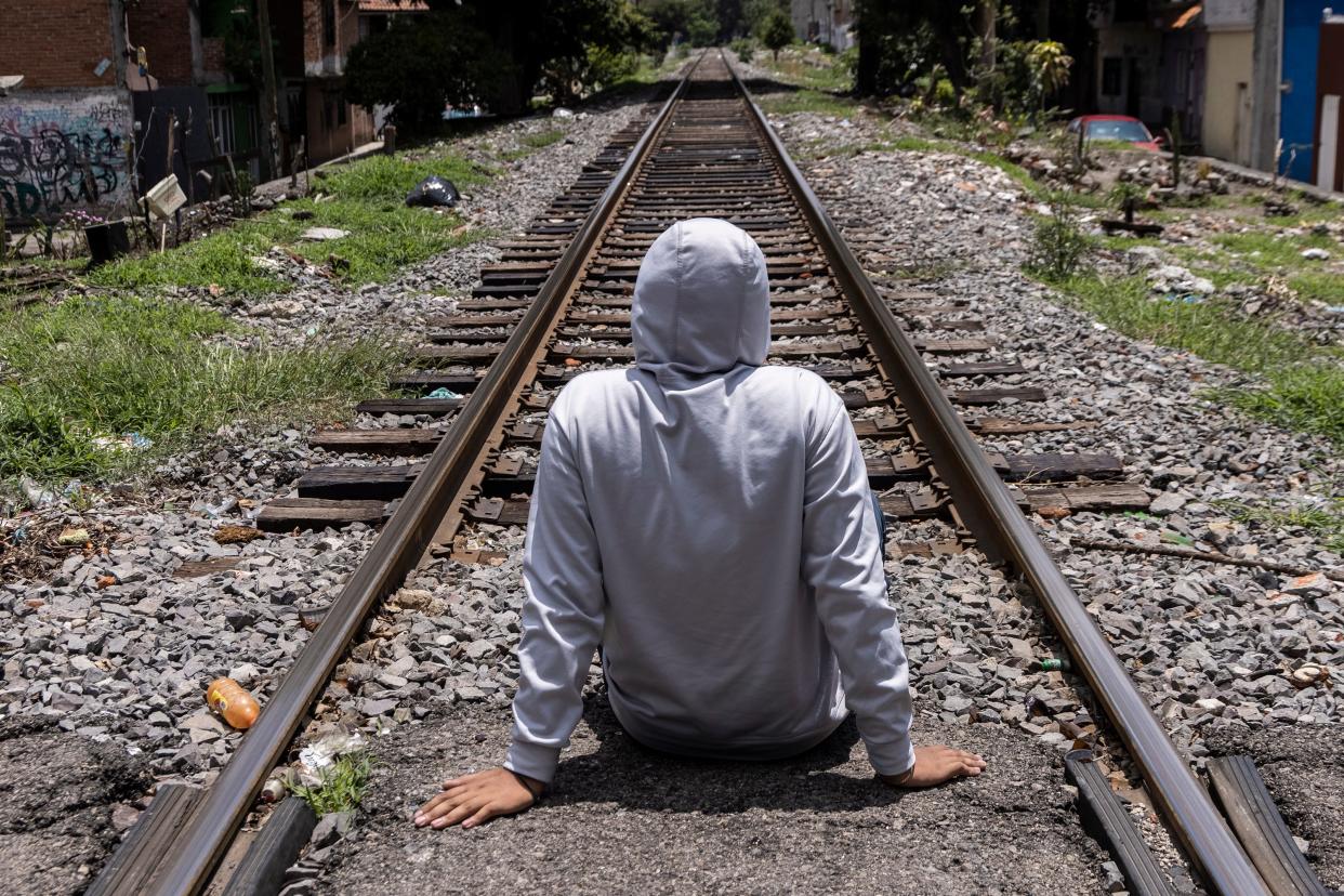 An 18-year-old hitman who works for the Jalisco New Generation Cartel (CJNG) sits for a photo in Morelia, Mexico. August 2023.