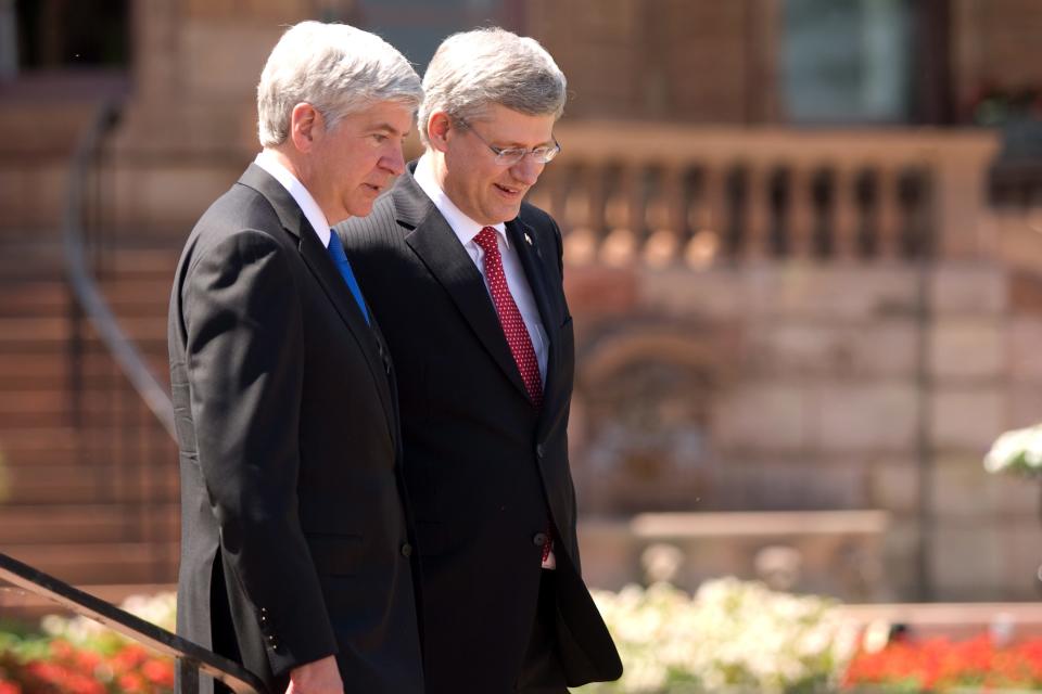 Prime Minister Stephen Harper right, and Michigan Governor Rick Snyder walk in front of the original Hiram Walker and Sons estate on the banks of the Detroit River in Windsor, Ontario, Canada, on Friday, June 15, 2012, ahead of an announcement for a new $1-billion bridge connecting the city with Detroit. (AP Photo/The Canadian Press,Mark Spowart )