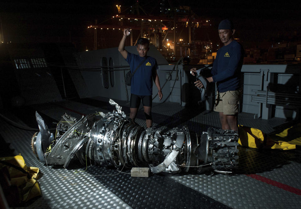 Navy divers inspect what is believed to be engine of the crashed Lion Air jet after it was retrieved from the sea floor, at Tanjung Priok Port in Jakarta, Indonesia, Saturday, Nov. 3, 2018. The brand new Boeing 737 MAX 8 jet plunged into the Java Sea just minutes after takeoff from Jakarta early on Oct. 29, killing all of its passengers on board. (AP Photo/Fauzy Chaniago)