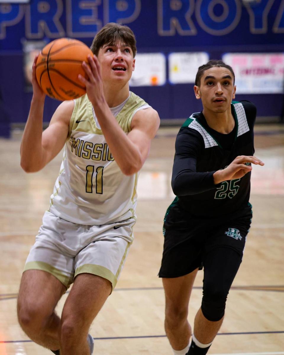 Roman Benedetti lines up a shot pursued by R.J. Franklin. Mission Prep overcame a first half deficit to finish with a win over Hoover of Fresno, 67-56, in a high school basketball playoff Feb. 20, 2024.