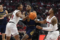 Notre Dame guard Blake Wesley (0) fights his way past Louisville guard Dre Davis (14), and guard Mason Faulkner (11) during the first half of an NCAA college basketball game in Louisville, Ky., Saturday, Jan. 22, 2022. (AP Photo/Timothy D. Easley)