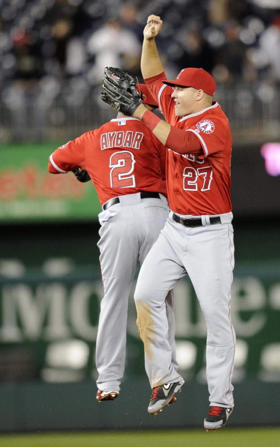 Los Angeles Angels center fielder Mike Trout (27) celebrates with teammate Erick Aybar (2) after a 4-2 win over the Washington Nationals with Erick Aybar (2) in a baseball game, Monday, April 21, 2014, in Washington. (AP Photo/Nick Wass)