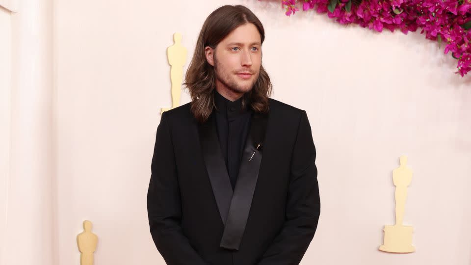 Composer Ludwig Göransson, nominated for Best Original Score for “Oppenheimer,” wore an all-black suit with an eloquent silver brooch pinned to the lapel. - Kevin Mazur/Getty Images