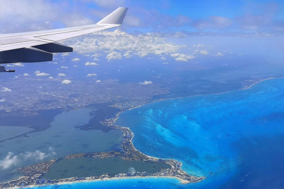 Airplane wing with Mexican Cancun coast Carribean Sea