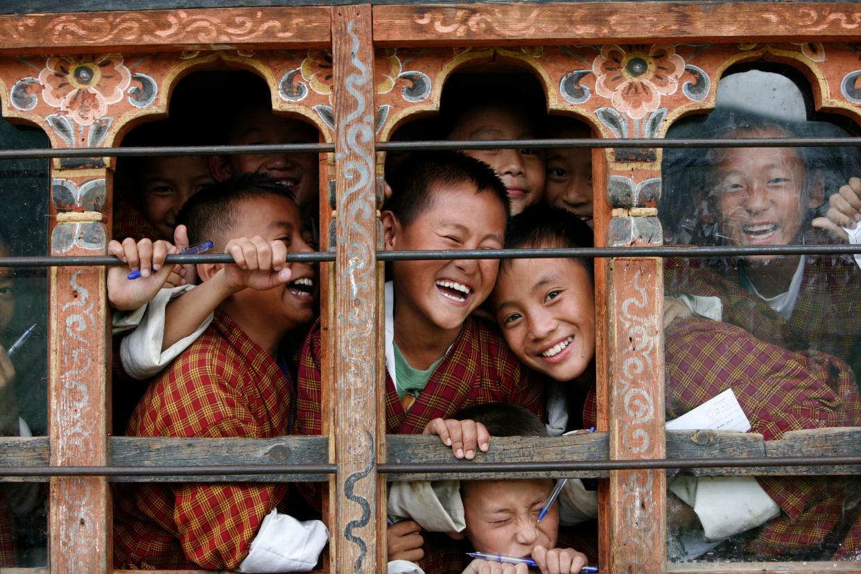 Schoolchildren react to the camera through the window of their classroom in a school in Thimphu, Bhutan, in 2010. Credit: Reuters (Photo: )