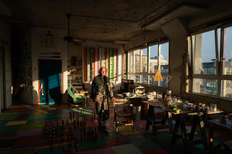 Steve Silver stands in a bathrobe bathed in the shadows pouring through his colorful Williamsburg studio.