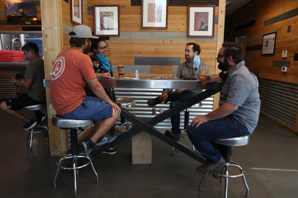 People sit at a table inside the Coachella Valley Brewing Co taproom in Thousand Palms, Calif., on Friday, June 12, 2020.