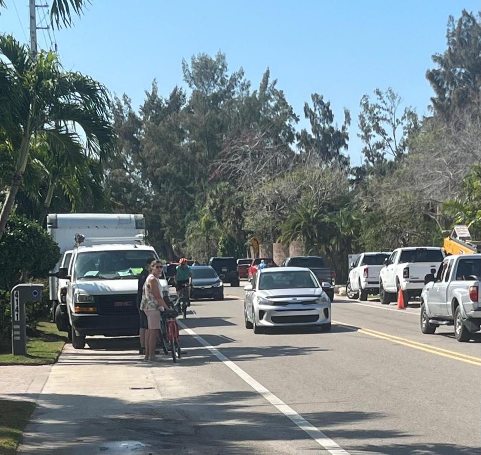 Cyclists waiting to enter the traffic lane on Siesta Key's Higel Avenue due to construction vehicles blocking the right of way.