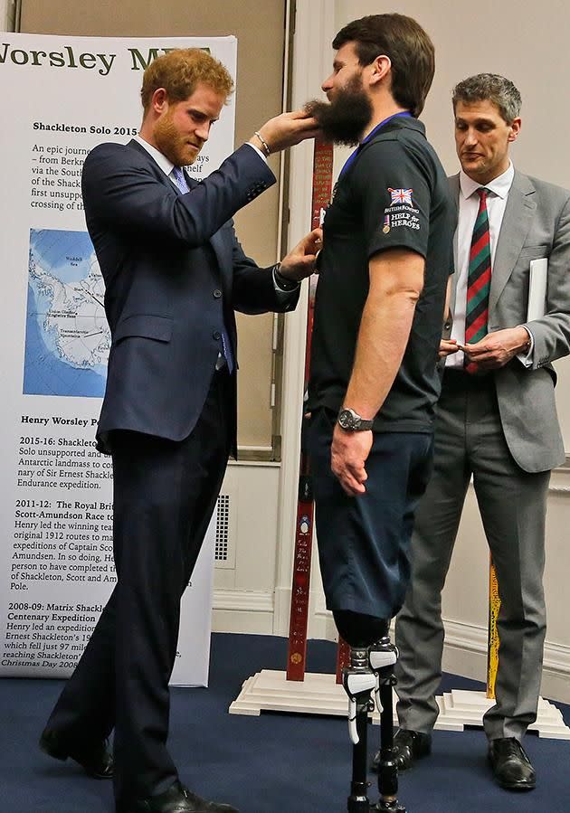 Prince Harry lifted war veteran Neil Heritage's beard as he presented him with a medal. Photo: Getty