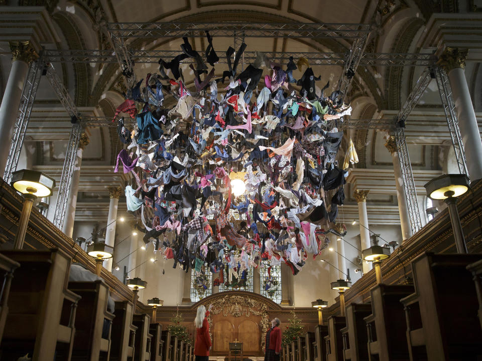 People view an installation artwork called Suspended, composed of items of clothing discarded by refugees on their arrival at Lesvos, by artist Arabella Dorman, at St James's Church on Piccadilly in London: AP