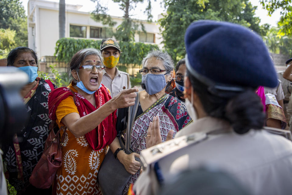 An Indian activist argues with a police officer before being detained by police during a protest in New Delhi, India, Wednesday, Sept. 30, 2020. The gang rape and killing of the woman from the lowest rung of India's caste system has sparked outrage across the country with several politicians and activists demanding justice and protesters rallying on the streets. (AP Photo/Altaf Qadri)