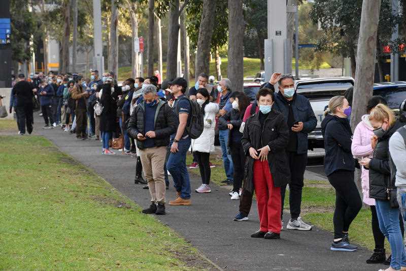 People are seen queued to receive their vaccination at the NSW Vaccine Centre at Homebush Olympic Park in Sydney.