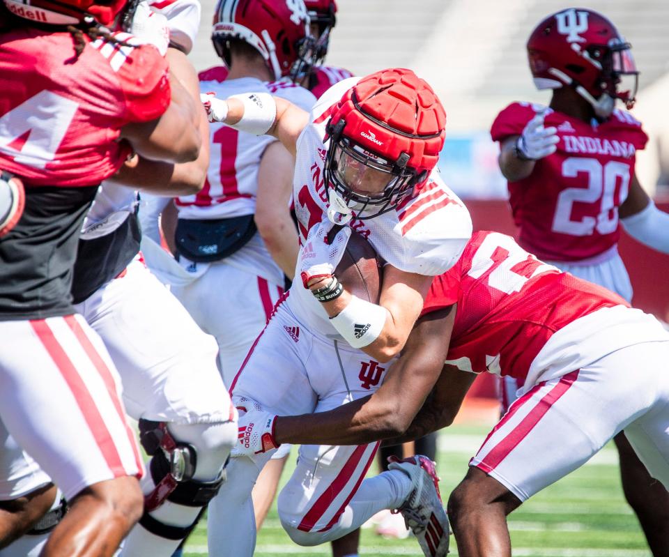 Indiana's Josh Henderson (26) is tackled by Jamari Sharpe (22) during Indiana football's Spring Football Saturday event at Memorial Stadium on Saturday, April 15, 2203.