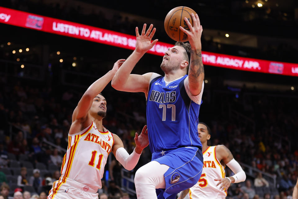 ATLANTA, GEORGIA - JANUARY 26: Luka Doncic #77 of the Dallas Mavericks goes up for a shot against Trae Young #11 of the Atlanta Hawks during the first quarter at State Farm Arena on January 26, 2024 in Atlanta, Georgia. NOTE TO USER: User expressly acknowledges and agrees that, by downloading and or using this photograph, User is consenting to the terms and conditions of the Getty Images License Agreement. (Photo by Todd Kirkland/Getty Images)