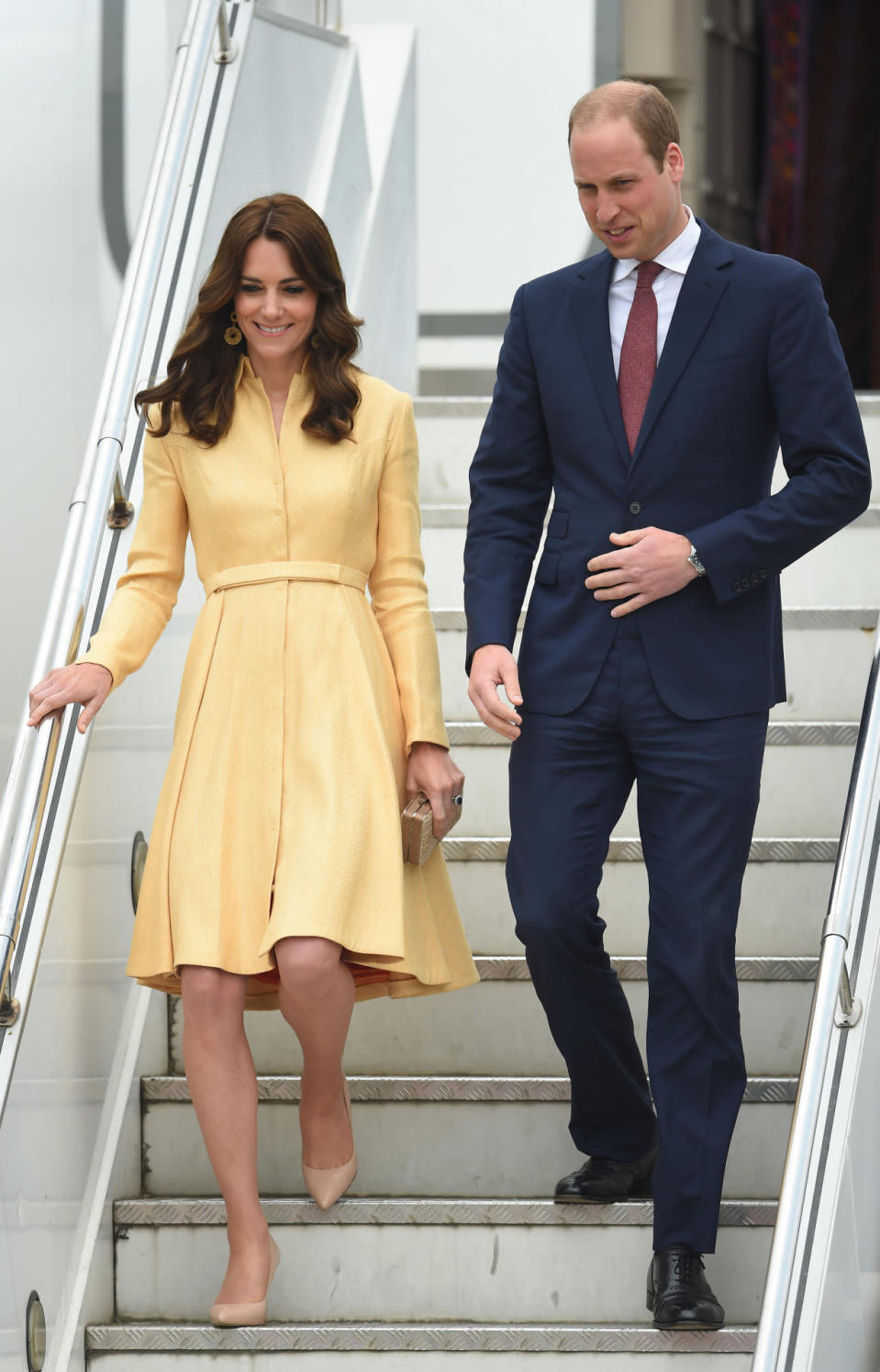 <p>Arriving in Bhutan, Kate looked lovely in a lemon yellow coat dress paired with nude heels and a gold box clutch. It’s not the first time the Duchess has worn the Emilia Wickstead number: She also donned it back in 2012. <i>[Photo: PA Images]</i></p>