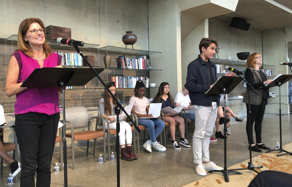 Actors Vanessa Lock, left, as Betsy DeVos, Cole Sitilides, center, and Jenny Waxman perform in the play "The Confirmation Hearing for the Secretary of Education" in Washington's Arena Stage theater on Monday, Sept. 17, 2018. In the play, about a dozen student actors from local high schools posed as frustrated Democrats and friendly Republicans to grill DeVos on the merits of public education, the role of the federal government in civil rights, and her family wealth. (AP Photo/Maria Danilova)