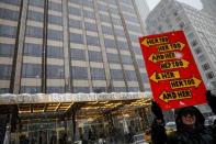 A protester holds a sign up during a #MeToo demonstration outside Trump International hotel in New York