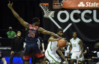 Arizona center Christian Koloko (35) tries to block the pass of Oregon guard LJ Figueroa (12) during the second half of an NCAA college basketball game Monday, March 1, 2021, in Eugene, Ore. (AP Photo/Andy Nelson)