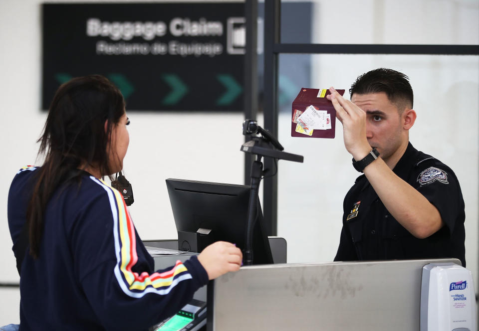 Un oficial de Aduanas y Protección Fronteriza de EE. UU. utiliza tecnología de reconocimiento facial en su stand en el Aeropuerto Internacional de Miami para examinar a un viajero que ingresa a los Estados Unidos el 27 de febrero de 2018 en Miami, Florida.  (Foto de Joe Raedle/Getty Images)