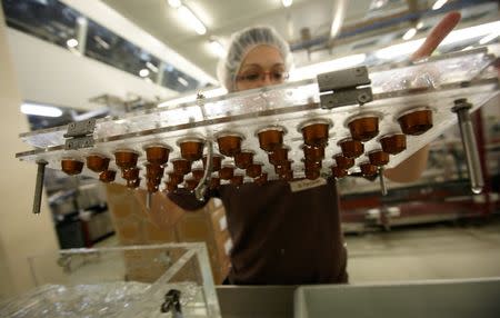 An employee removes a rack of capsules after a waterproof quality check at Nespresso production and distribution centre in Avenches near Bern, Switzerland May 24, 2011. REUTERS/Denis Balibouse/File Photo