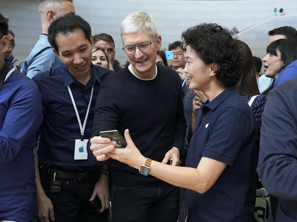 Apple CEO Tim Cook, center, looks at the the new iPhone 11 Pro Max, during an event to announce new products Tuesday, Sept. 10, 2019, in Cupertino, Calif. (AP Photo/Tony Avelar)