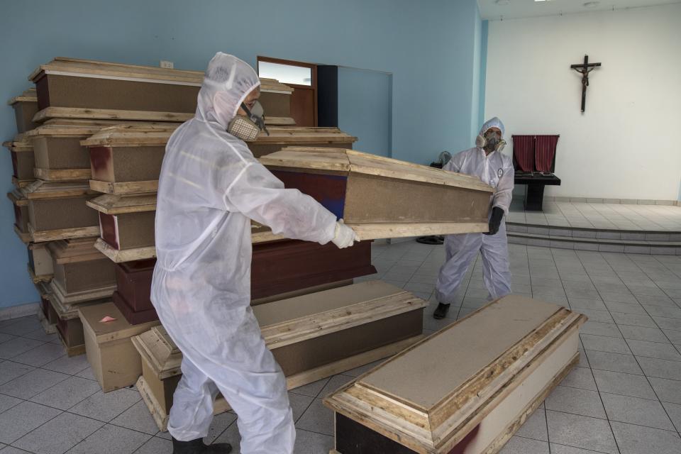 Empleados de una funeraria preparan los ataúdes que van a ser llevaso a un hospital público para enterrar a personas que se cree fallecieron por el coronavirus. Foto del 20 de mayo del 2020. (AP Photo/Rodrigo Abd)